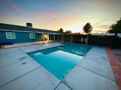 a swimming pool in front of a house at Western style pool home, 4 bedroom and large yard in Apple Valley