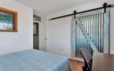 a bedroom with a bed and a table and a window at Western style pool home, 4 bedroom and large yard in Apple Valley