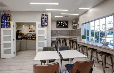 a bar with tables and chairs in a restaurant at Elev8 Hotel Los Angeles, LAX in Inglewood