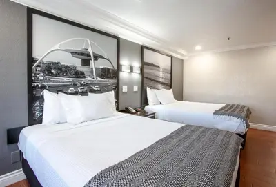 a hotel room with two beds and a picture on the wall at Elev8 Hotel Los Angeles, LAX in Inglewood