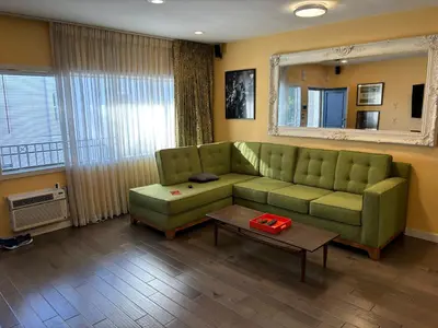 a living room with a green couch and a table at west hollywood condo in Los Angeles