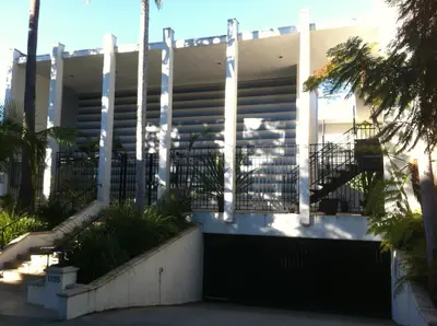 a building with a gate and palm trees at west hollywood condo in Los Angeles