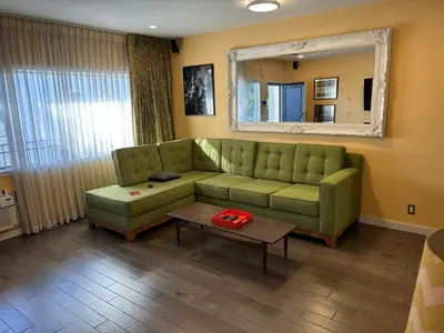 a living room with a green couch and a table at west hollywood condo in Los Angeles