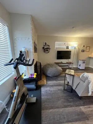 a living room with a room with a treadmill at Sunny Retro Row Condo- Walk to Beach! in Long Beach