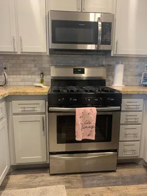a kitchen with a stainless steel stove and a microwave at Sunny Retro Row Condo- Walk to Beach! in Long Beach