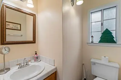 a bathroom with a sink and a toilet and a window at Casa de Yukon & Black stone Grill, 3 Level Home in Lake Arrowhead