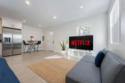 a living room with a couch and a kitchen at Prestige Studio Haven at Burbank in Burbank