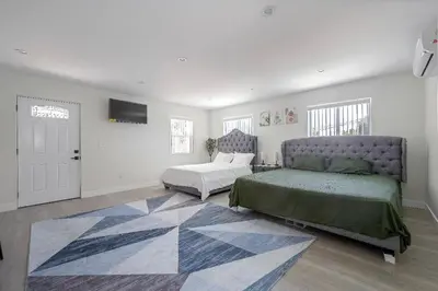 a bedroom with two beds and a couch and a television at Prestige Studio Haven at Burbank in Burbank