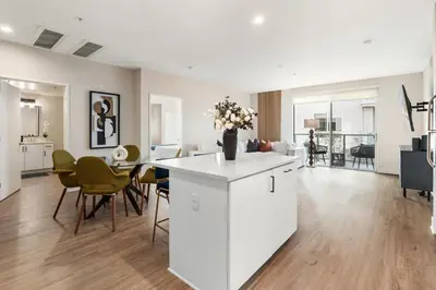 a white kitchen and living room with a table and chairs at Spinel Stay - Charming 2BR Retreat Zen Garden Views Central in Los Angeles