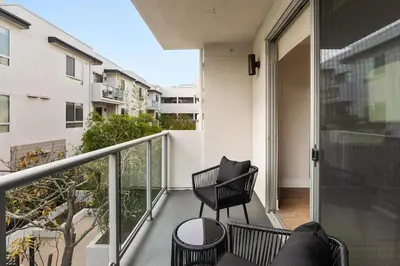 a balcony with two chairs and a table on a building at Spinel Stay - Charming 2BR Retreat Zen Garden Views Central in Los Angeles
