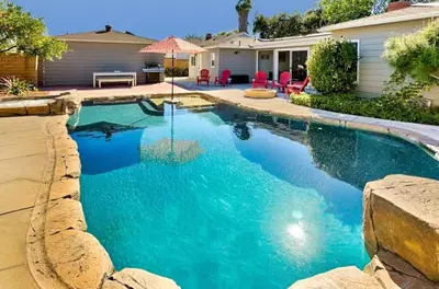 a swimming pool with blue water in a backyard at Peaceful Retreat in Anaheim-close to Disney in Anaheim
