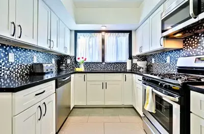 a kitchen with white cabinets and black counter tops at Peaceful Retreat in Anaheim-close to Disney in Anaheim