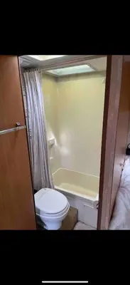 a small bathroom with a toilet and a bath tub at Cozy private couples camper in San Gabriel CA in San Gabriel