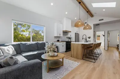 a living room and kitchen with a couch and a table at The Oaks, Stylish Luxury Stay, Fire Pit & Patio in Thousand Oaks