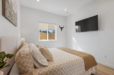 a white bedroom with a bed with pillows on it at The Oaks, Stylish Luxury Stay, Fire Pit & Patio in Thousand Oaks