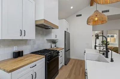 a kitchen with white cabinets and a stove top oven at The Oaks, Stylish Luxury Stay, Fire Pit & Patio in Thousand Oaks