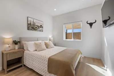 a white bedroom with a bed and a window at The Oaks, Stylish Luxury Stay, Fire Pit & Patio in Thousand Oaks