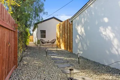 a backyard with a stone walkway next to a fence at The Oaks, Stylish Luxury Stay, Fire Pit & Patio in Thousand Oaks