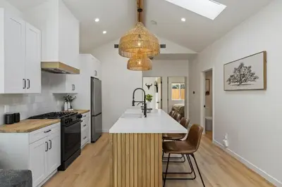 a kitchen with white cabinets and a island with a sink at The Oaks, Stylish Luxury Stay, Fire Pit & Patio in Thousand Oaks