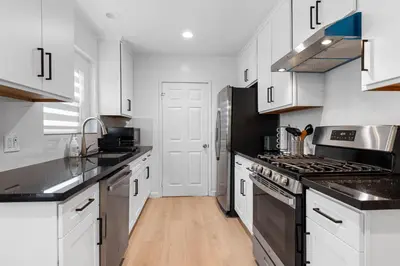 a kitchen with white cabinets and black appliances at Cozy 3BR in San Gabriel in San Gabriel