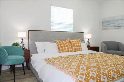 a bedroom with a bed and a blue chair at Single family house in Long Beach