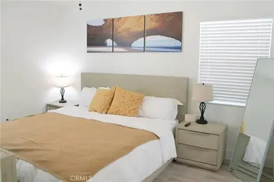 a bedroom with a large bed with two lamps on it at Single family house in Long Beach