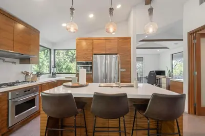 a kitchen with a large white island with bar chairs at Cozy Oasis in Oakley with Basketball court pool in Los Angeles