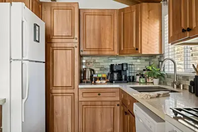 a kitchen with wooden cabinets and a white refrigerator at Wild Heart Cabin in Big Bear Lake