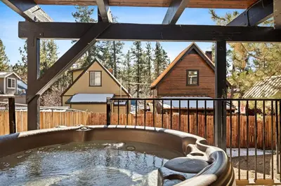 a hot tub in a backyard with a wooden fence at Wild Heart Cabin in Big Bear Lake