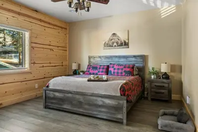 a bedroom with a bed and a wooden wall at High Altitude Retreat in Big Bear Lake