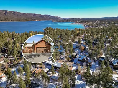 an aerial view of a lodge with snow covered trees and a lake at High Altitude Retreat in Big Bear Lake