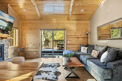 a living room with a couch and a table at High Altitude Retreat in Big Bear Lake