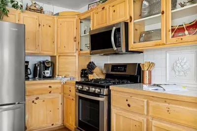 a kitchen with wooden cabinets and a stove top oven at Boulder Bay Waterfront Breeze in Big Bear Lake