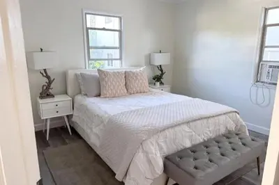 a white bedroom with a bed and two windows at Fully remodeled 1 bedroom in prime West Hollywood in Los Angeles