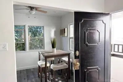 a dining room with a table and a black door at Fully remodeled 1 bedroom in prime West Hollywood in Los Angeles