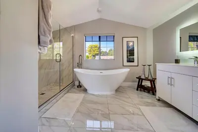 a bathroom with a tub and a glass shower at Stunning Hilltop 5BR With View And Hot Tub! in Lakeside Park
