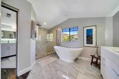 a white bathroom with a tub and a shower at Stunning Hilltop 5BR With View And Hot Tub! in Lakeside Park
