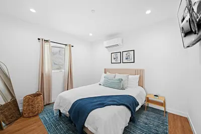 a white bedroom with a bed and a window at Spanish Style Guesthouse Unit 1 in Los Angeles
