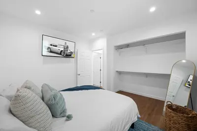 a white bedroom with a bed and a car on the wall at Spanish Style Guesthouse Unit 1 in Los Angeles