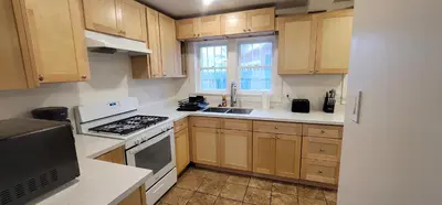 a kitchen with wooden cabinets and a stove top oven at Private 3 bedroom Home in Los Angeles - Gardena, California in Gardena