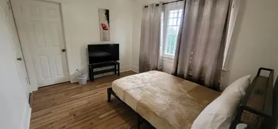 a bedroom with a bed and a tv and a window at Private 3 bedroom Home in Los Angeles - Gardena, California in Gardena