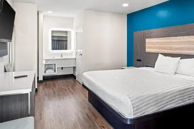 a bedroom with a bed and a blue wall at La Mirage Inn - Long Beach in Long Beach