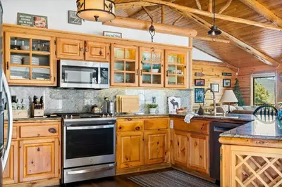 a kitchen with wooden cabinets and a stove top oven at Its a Wonderful Lodge in Big Bear Lake