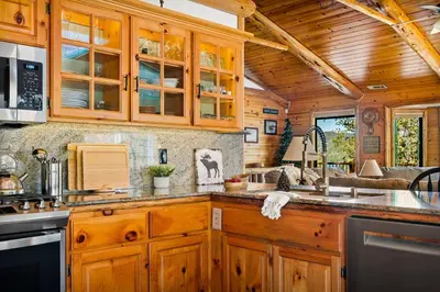 a kitchen in a cabin with wooden cabinets at Its a Wonderful Lodge in Big Bear Lake