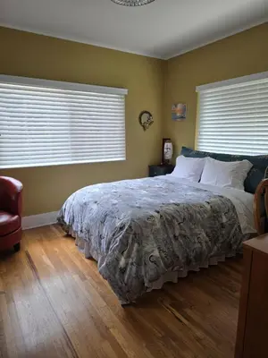 a bedroom with a large bed and two windows at The Ginkgo House in Pasadena