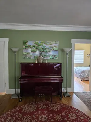 a piano in a living room with a bedroom at The Ginkgo House in Pasadena