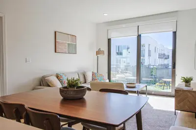 a living room with a table and a couch at Beachside 2BD 2BA, 12Min Walk to Santa Monica Pier in Los Angeles