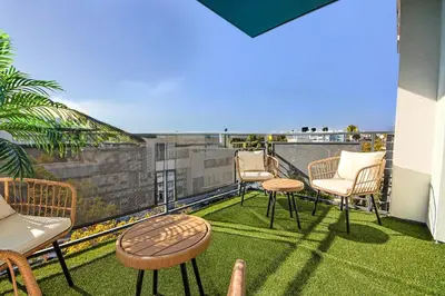 a patio with chairs and tables on a balcony at Beachside 2BD 2BA, 12Min Walk to Santa Monica Pier in Los Angeles
