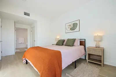 a bedroom with a bed with an orange blanket at Beachside 2BD 2BA, 12Min Walk to Santa Monica Pier in Los Angeles