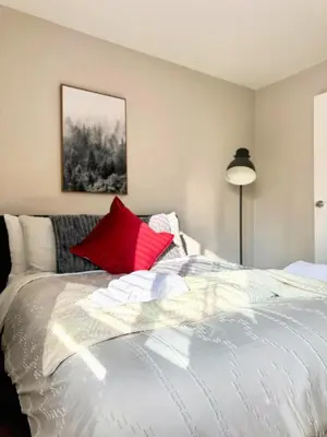 a bedroom with a white bed with red pillows at Fire Support 3Bedroom Modern Luxury House in Central Pasadena in Pasadena